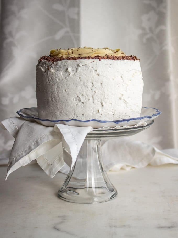 Bolo de chocolate com geada branca em um carrinho de bolo.